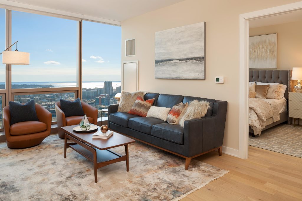 Living room with floor-to-ceiling windows and city view.
